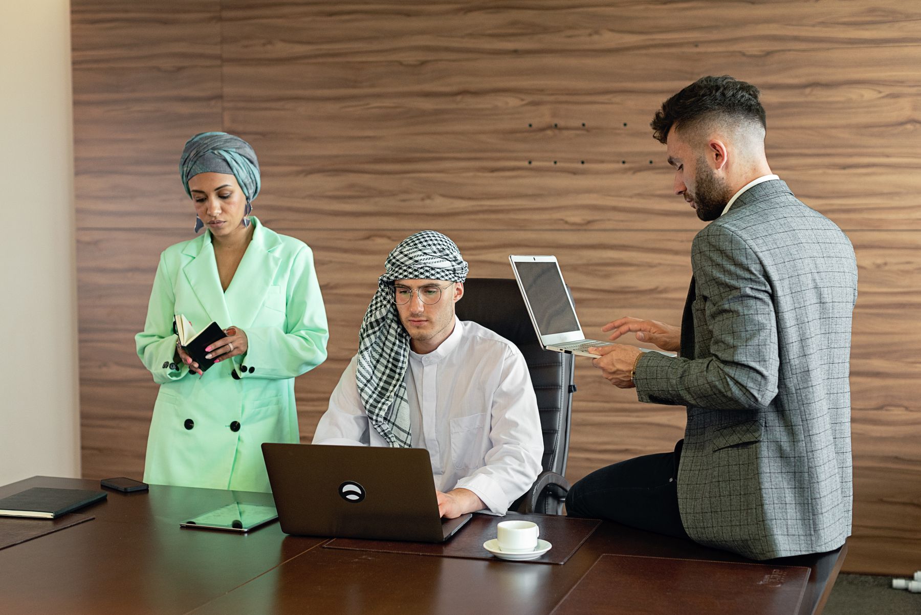 Illustrative multicultural colleagues interacting naturally in a UAE workplace.